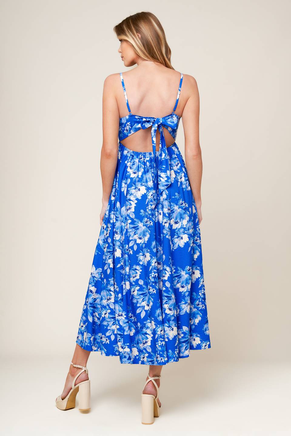 A printed woven midi dress featuring straight neckline, straps, full skirt, back tie and elasticized back