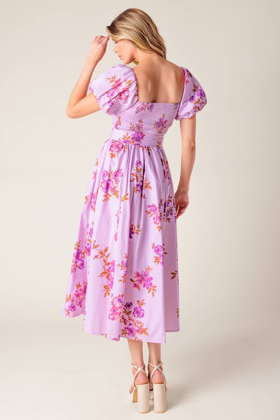 A lavender printed woven midi dress featuring on/off shoulder neckline, shirred bodice, self sash tie, full skirt and smocked back bodice.