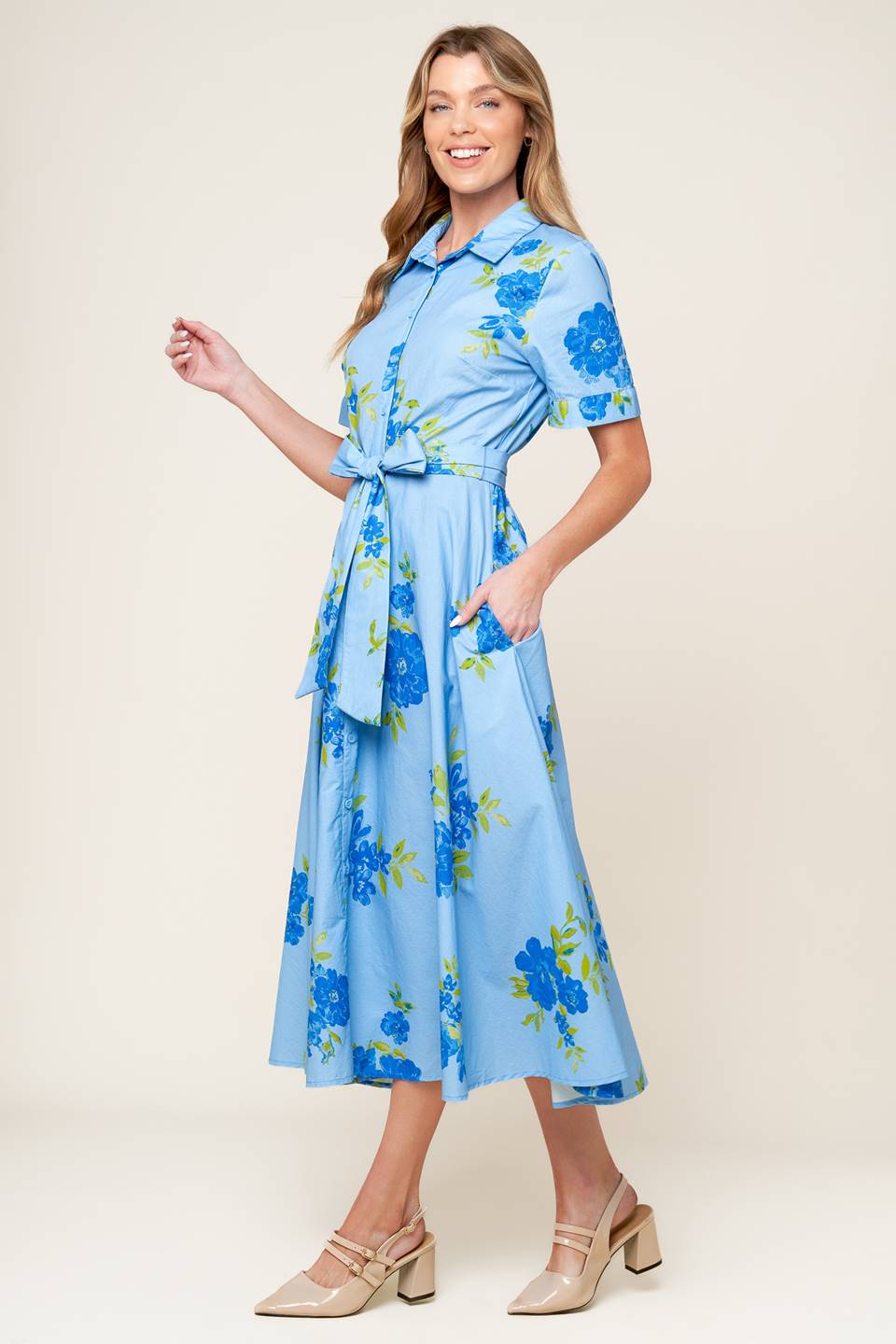 A powder blue printed woven midi dress featuring shirt collar, button down, short sleeves, self sash tie, and full skirt.