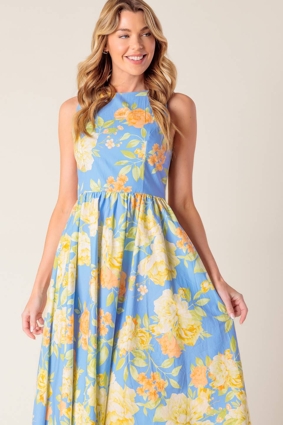 A powder blue floral printed woven midi dress featuring round neckline, sleeveless, full skirt, open back with tie and zipper closure.