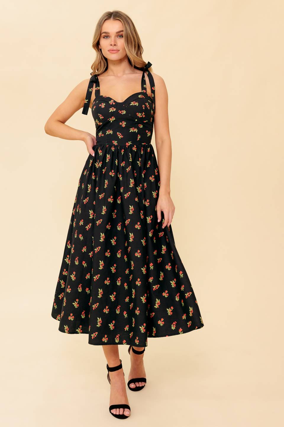 A printed woven midi dress featuring bustier top, shoulder tie, full skirt and smocked back bodice.