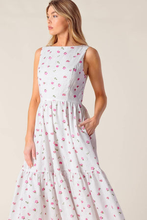 A printed woven eyelet midi dress featuring round neckline, sleeveless, ruffled hem, U back with tie and zipper closure