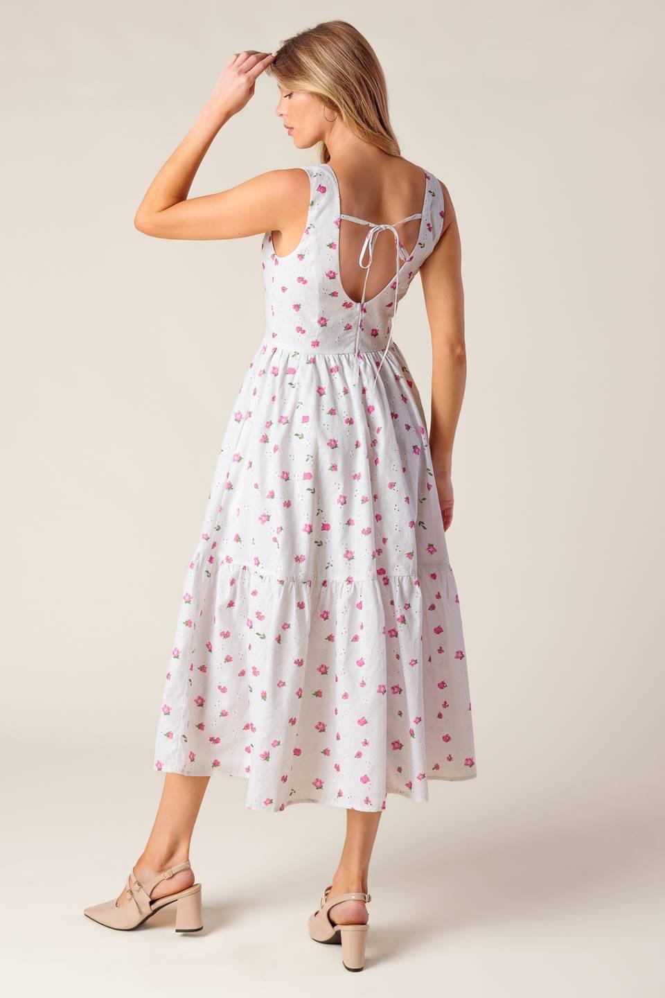 A printed woven eyelet midi dress featuring round neckline, sleeveless, ruffled hem, U back with tie and zipper closure