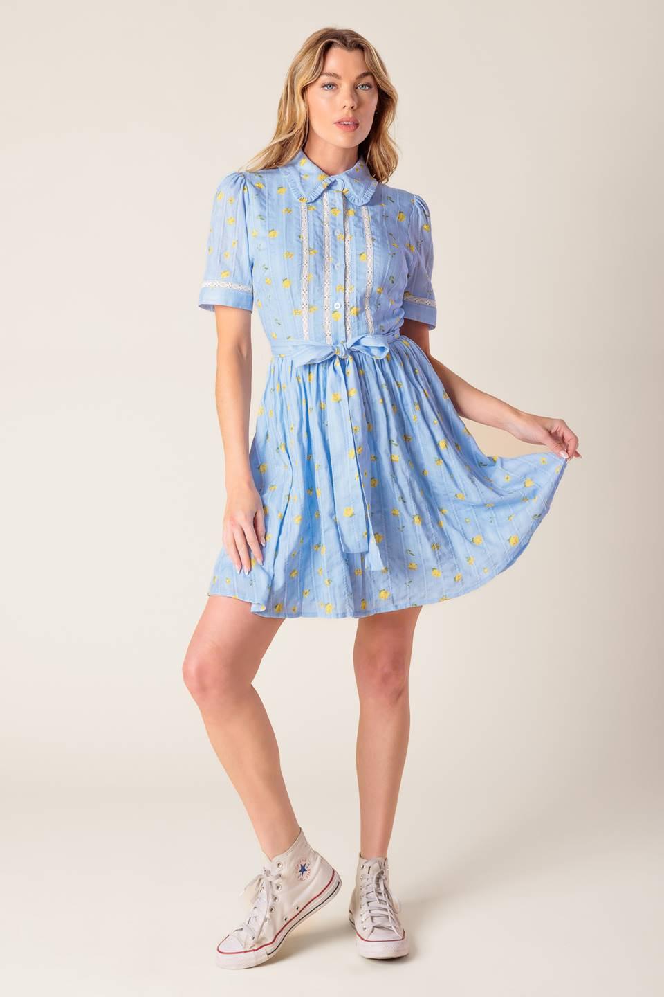 A blue printed woven mini dress featuring collar, button down, short sleeve, lace inset, self sash and full skirt on a white background | Flying Tomato
