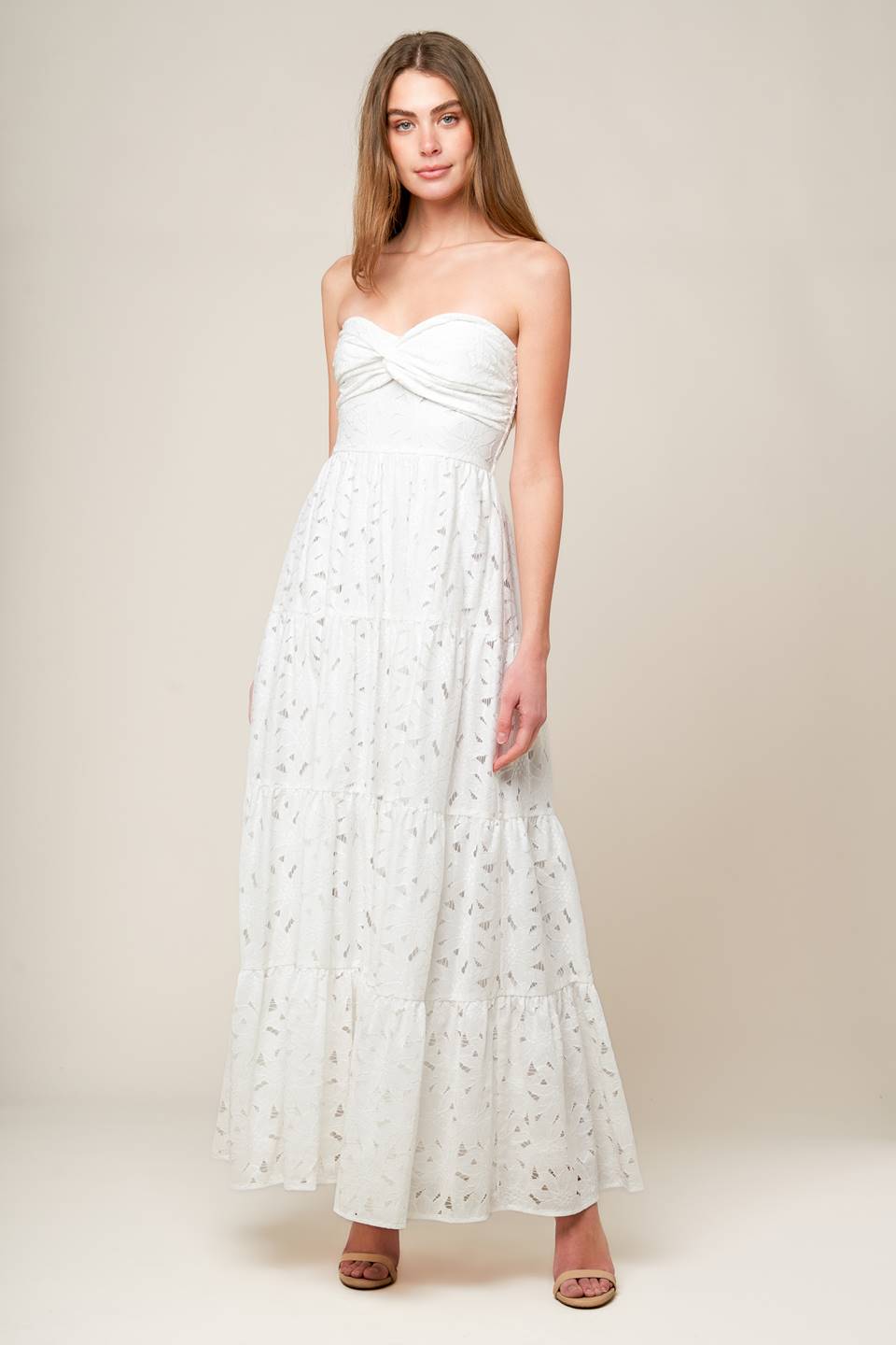 A white woven lace maxi dress featuring strapless, twist bodice, tiered skirt and smocked back bodice.