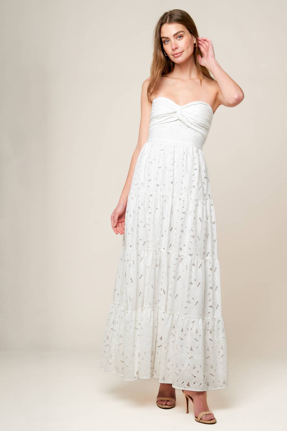 A white woven lace maxi dress featuring strapless, twist bodice, tiered skirt and smocked back bodice.