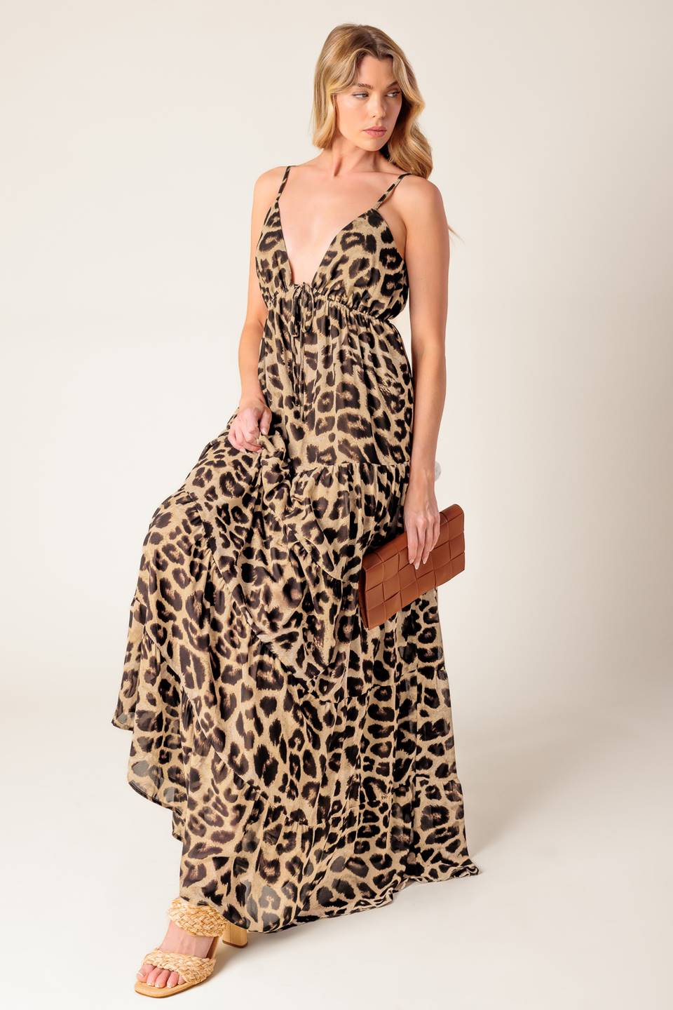 A leopard printed woven maxi dress featuring cami bodice, elasticized empire with front tie, adjustable straps and tiered skirt.