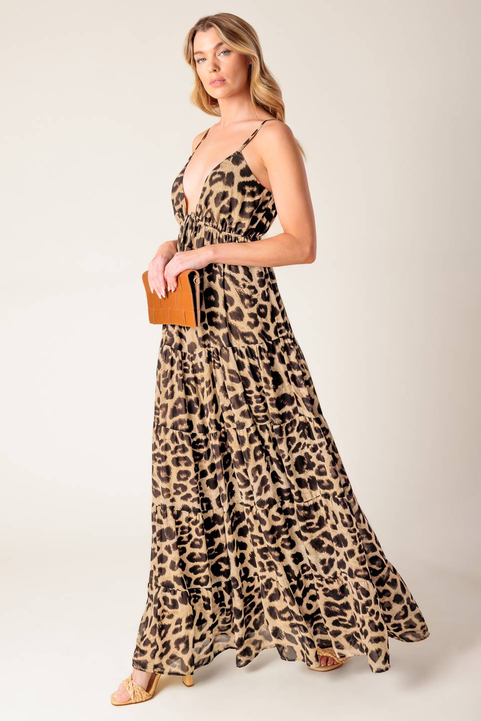 A leopard printed woven maxi dress featuring cami bodice, elasticized empire with front tie, adjustable straps and tiered skirt.