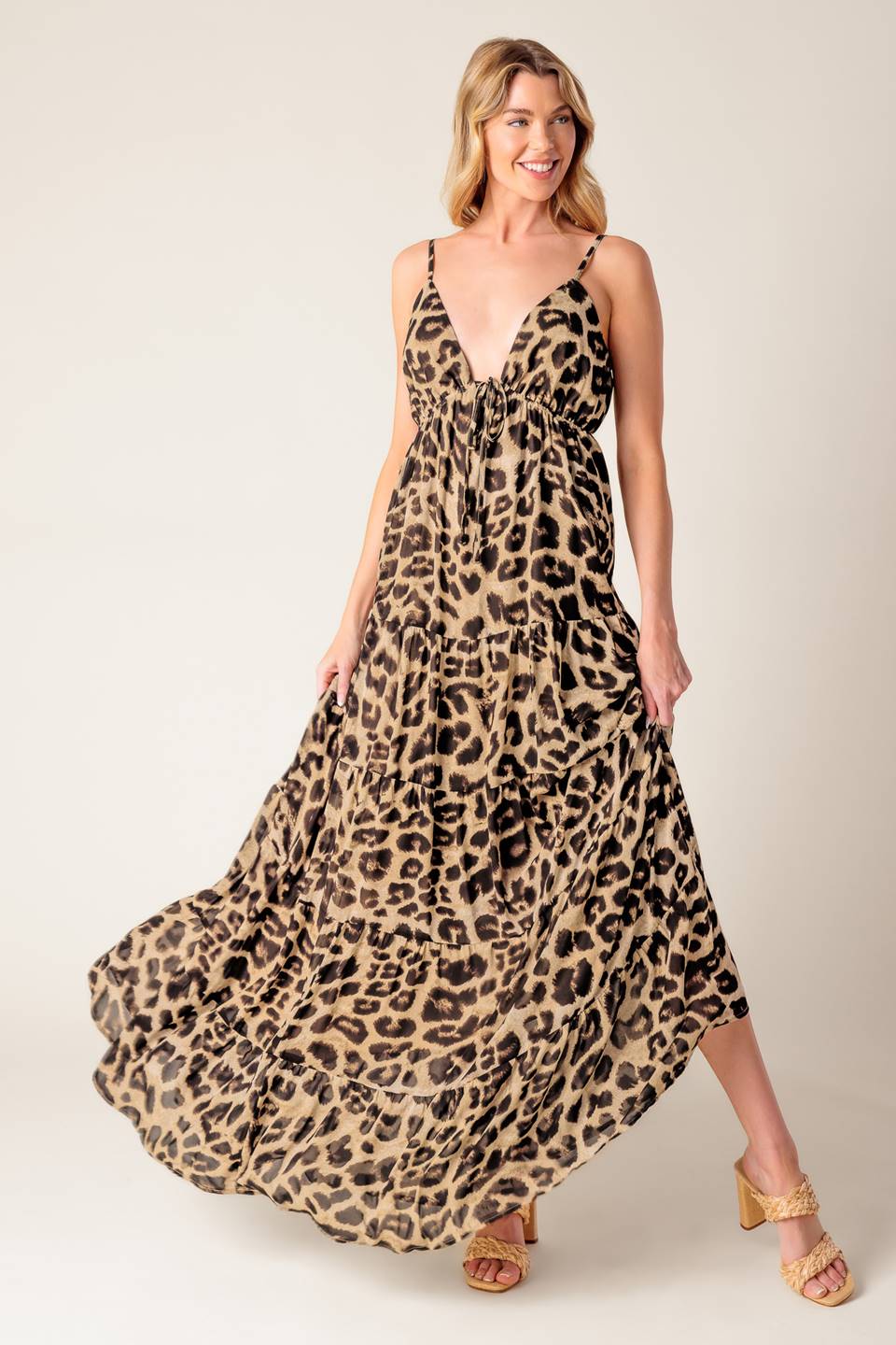 A leopard printed woven maxi dress featuring cami bodice, elasticized empire with front tie, adjustable straps and tiered skirt.