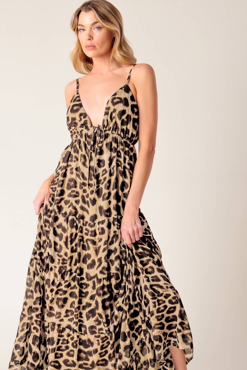 A leopard printed woven maxi dress featuring cami bodice, elasticized empire with front tie, adjustable straps and tiered skirt.