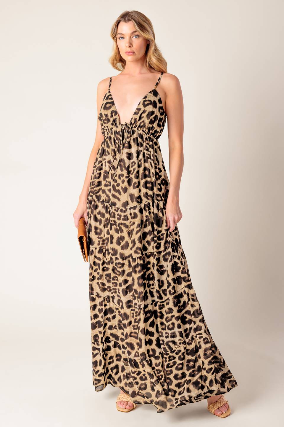 A leopard printed woven maxi dress featuring cami bodice, elasticized empire with front tie, adjustable straps and tiered skirt.