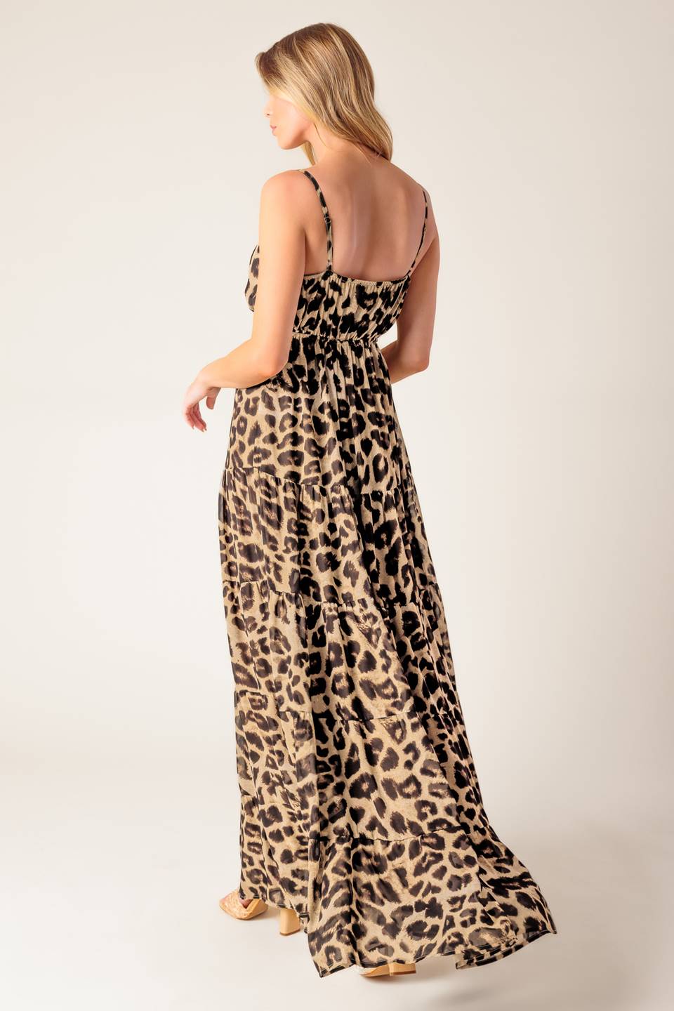 A leopard printed woven maxi dress featuring cami bodice, elasticized empire with front tie, adjustable straps and tiered skirt.