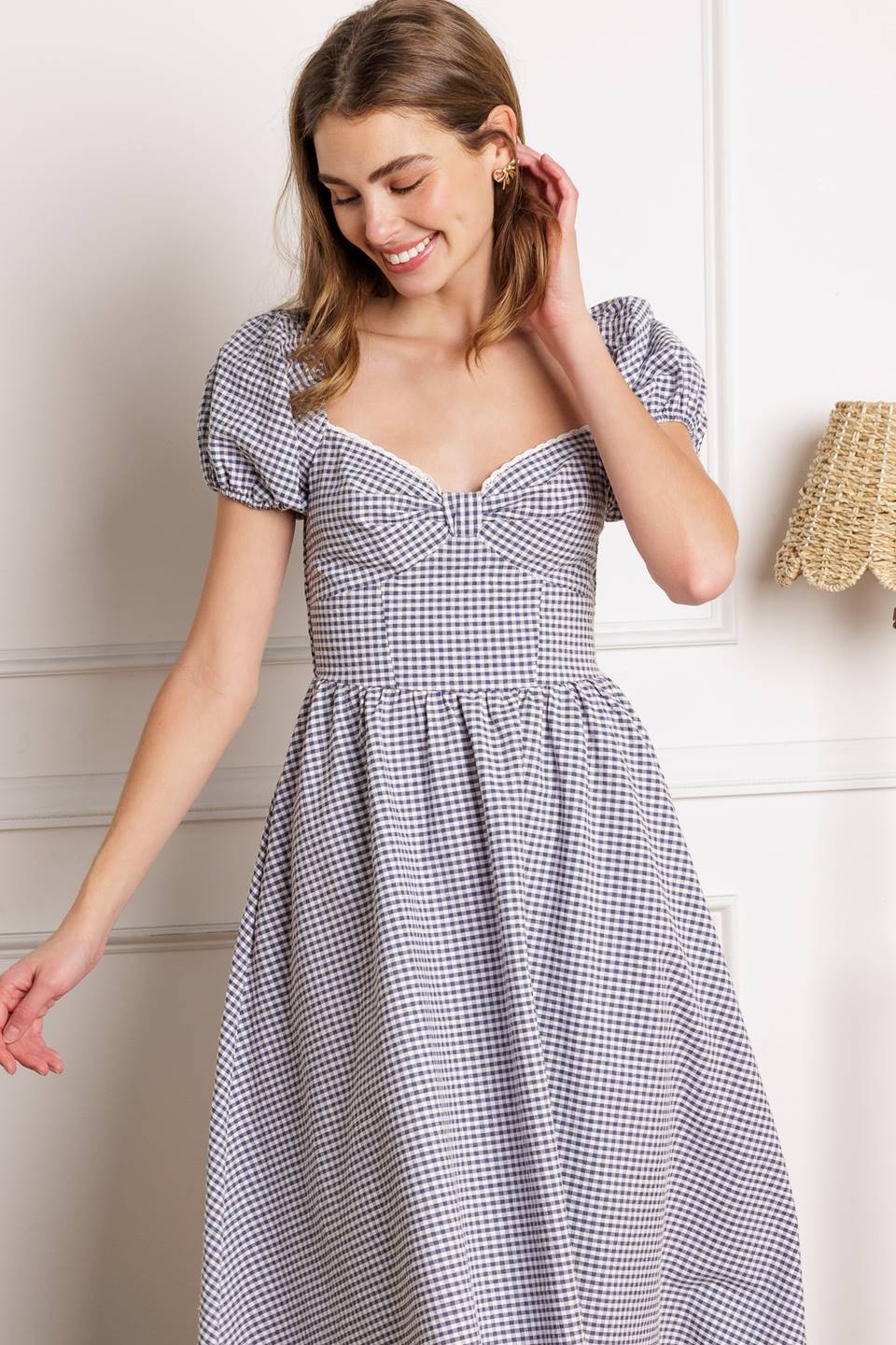 A woven gingham midi dress featuring sweetheart neckline with lace edge and bow bodice, short puff sleeve, full skirt and smocked back bodice