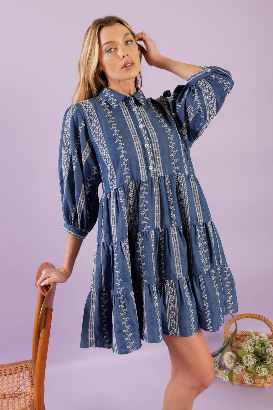 A woven embroidered fabric mini dress featuring collar, button down at bodice, 3/4 sleeve and tiered skirt