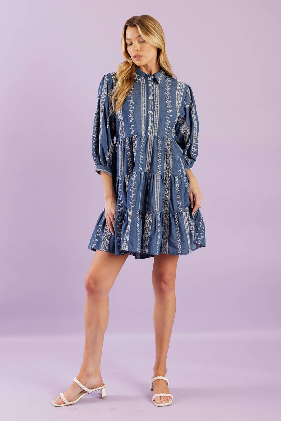 A woven embroidered fabric mini dress featuring collar, button down at bodice, 3/4 sleeve and tiered skirt