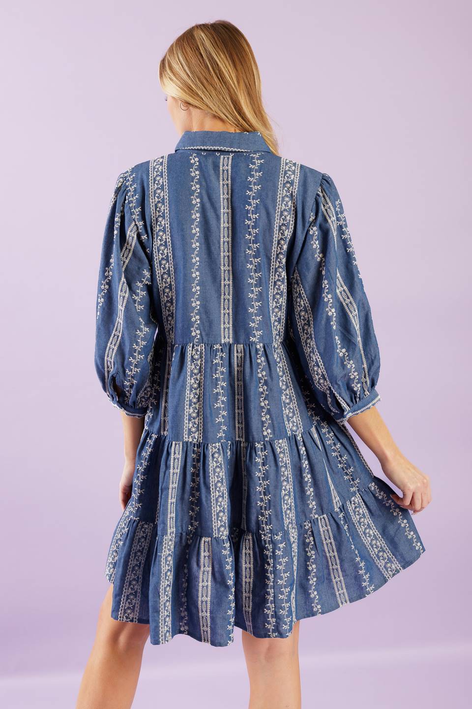 A woven embroidered fabric mini dress featuring collar, button down at bodice, 3/4 sleeve and tiered skirt