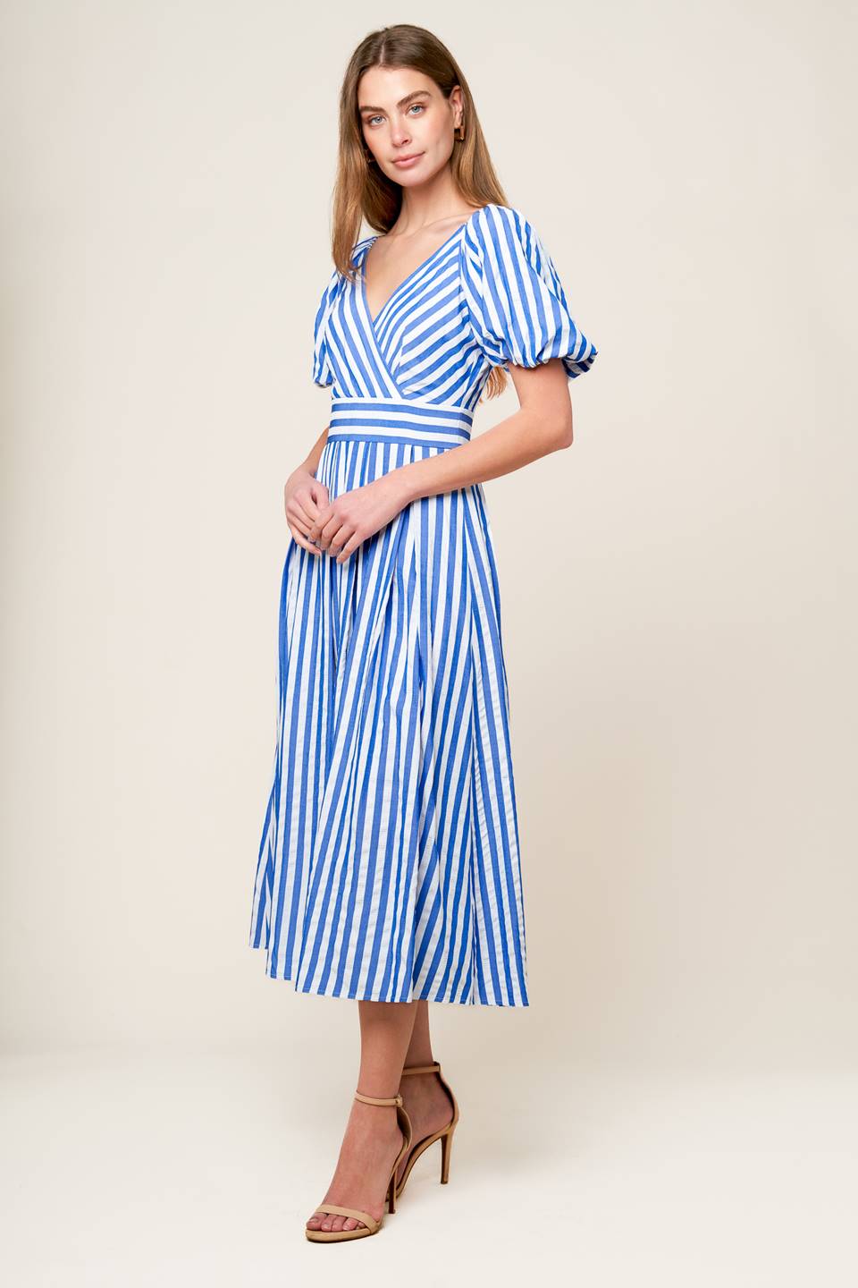 A blue and white striped woven midi dress featuring surplice neckline, short puff sleeve, full skirt and back zipper closure.