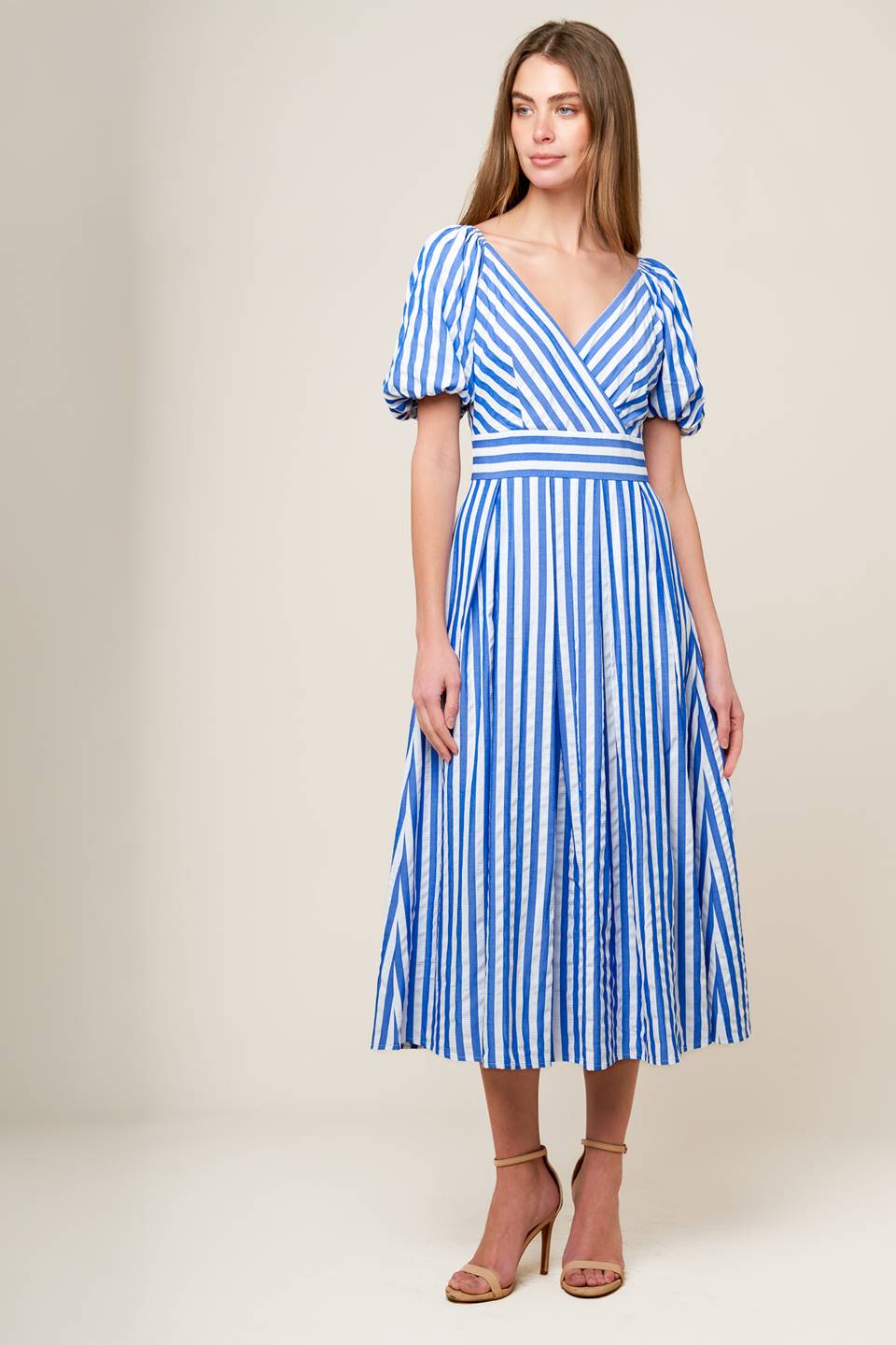 A blue and white striped woven midi dress featuring surplice neckline, short puff sleeve, full skirt and back zipper closure.