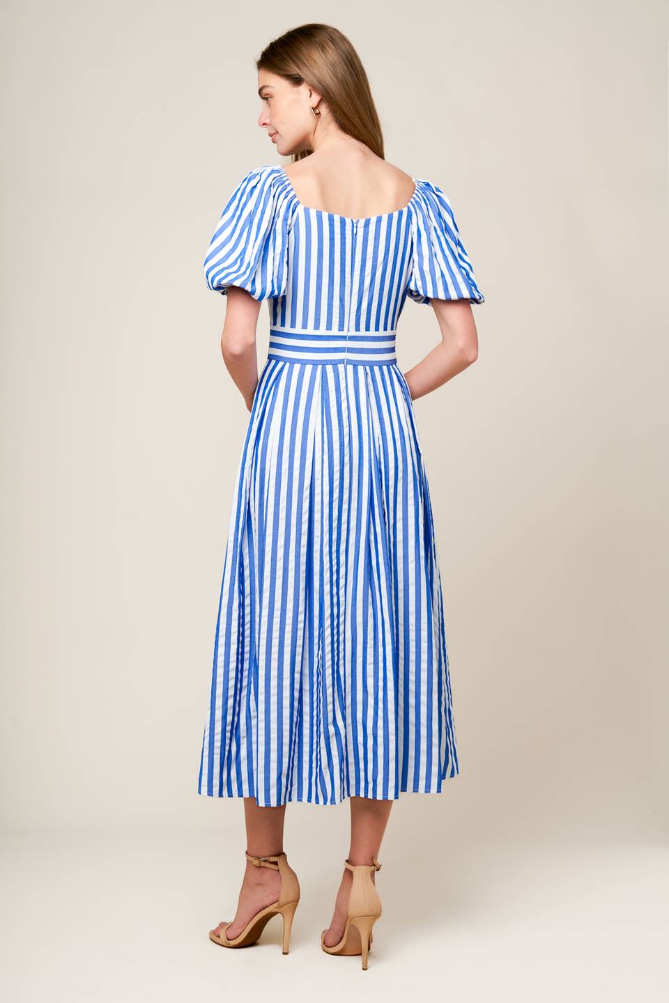 A blue and white striped woven midi dress featuring surplice neckline, short puff sleeve, full skirt and back zipper closure.