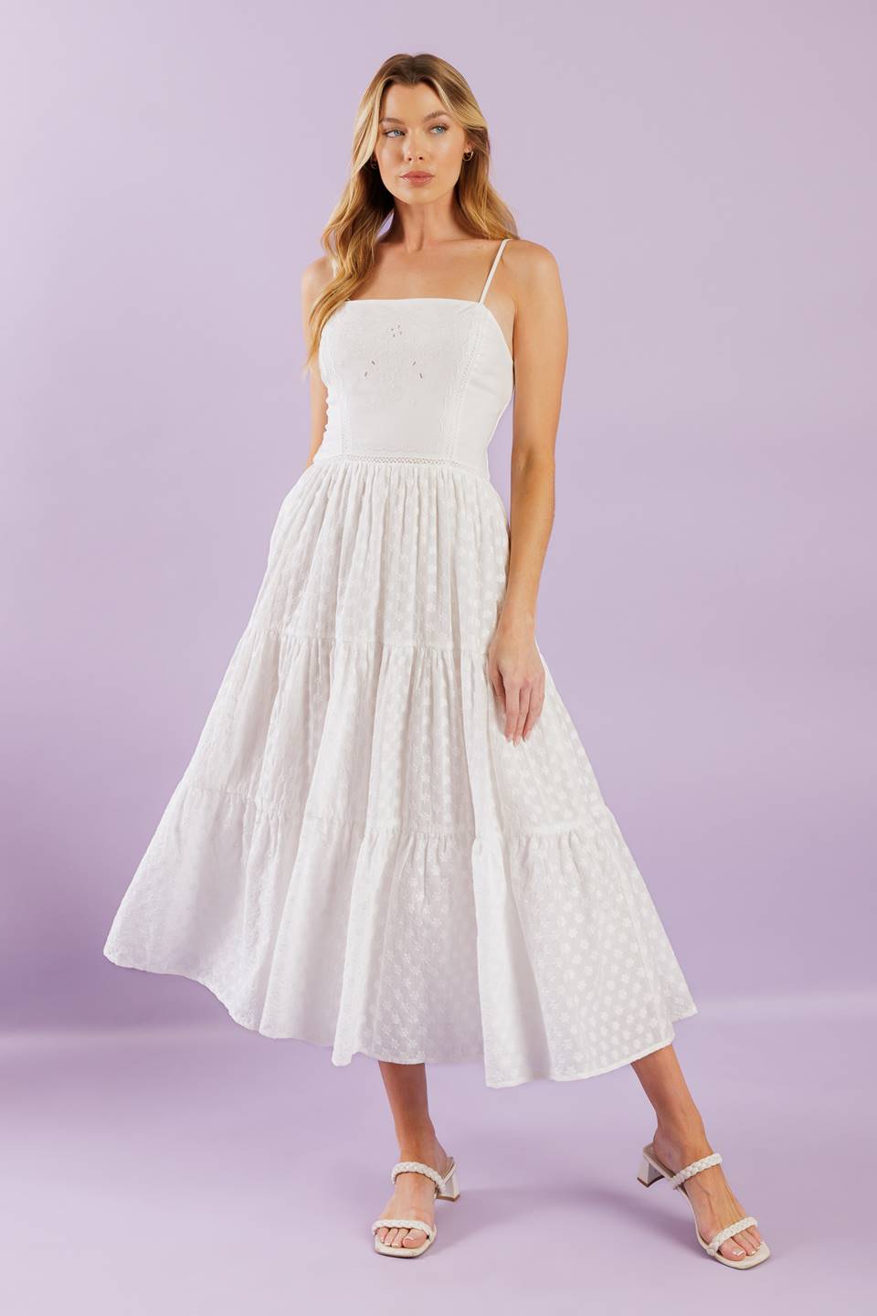 A solid woven midi dress featuring straight neckline with straps, embroidered bodice, textured tiered skirt and smocked back bodice