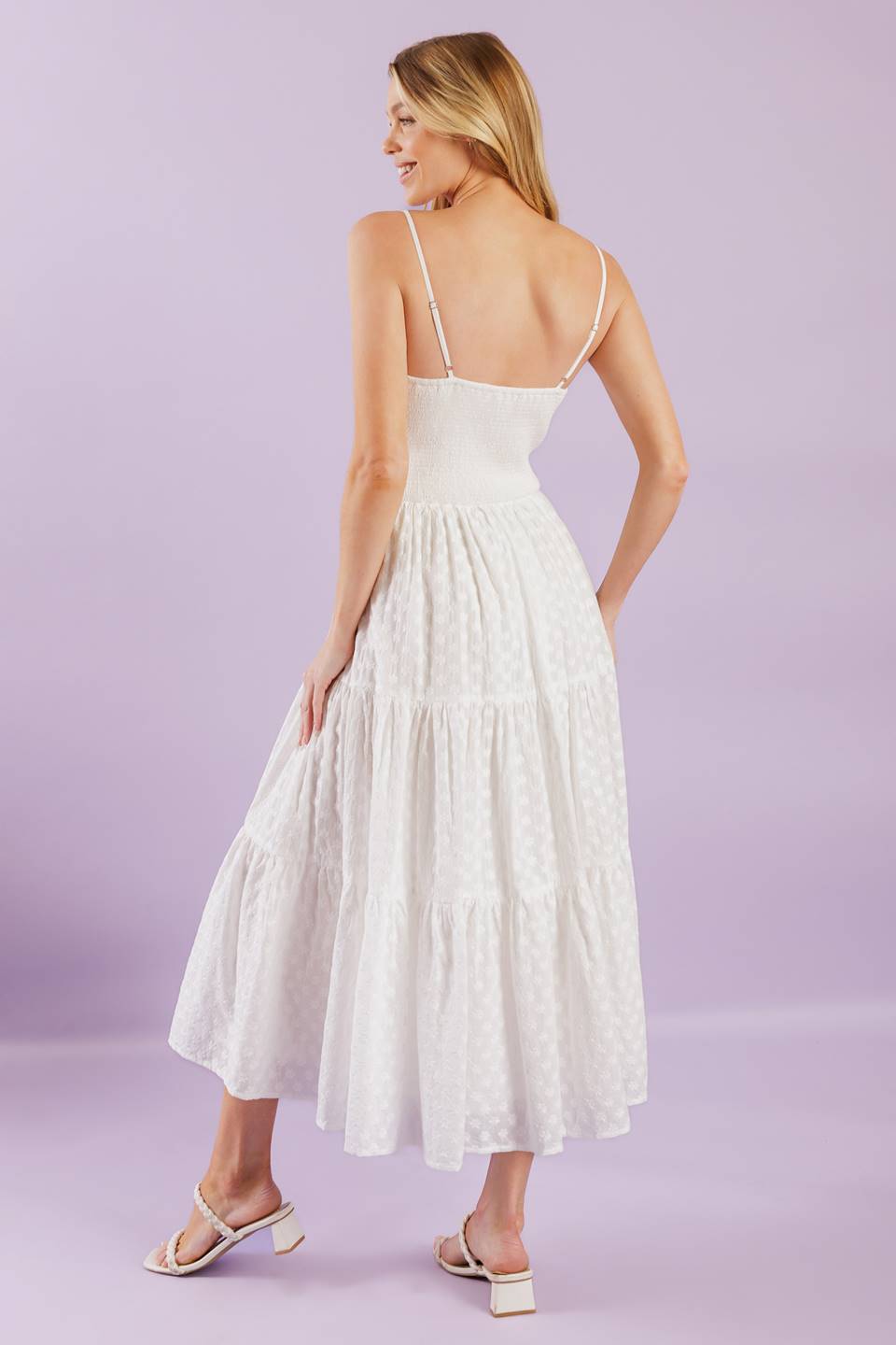 A solid woven midi dress featuring straight neckline with straps, embroidered bodice, textured tiered skirt and smocked back bodice