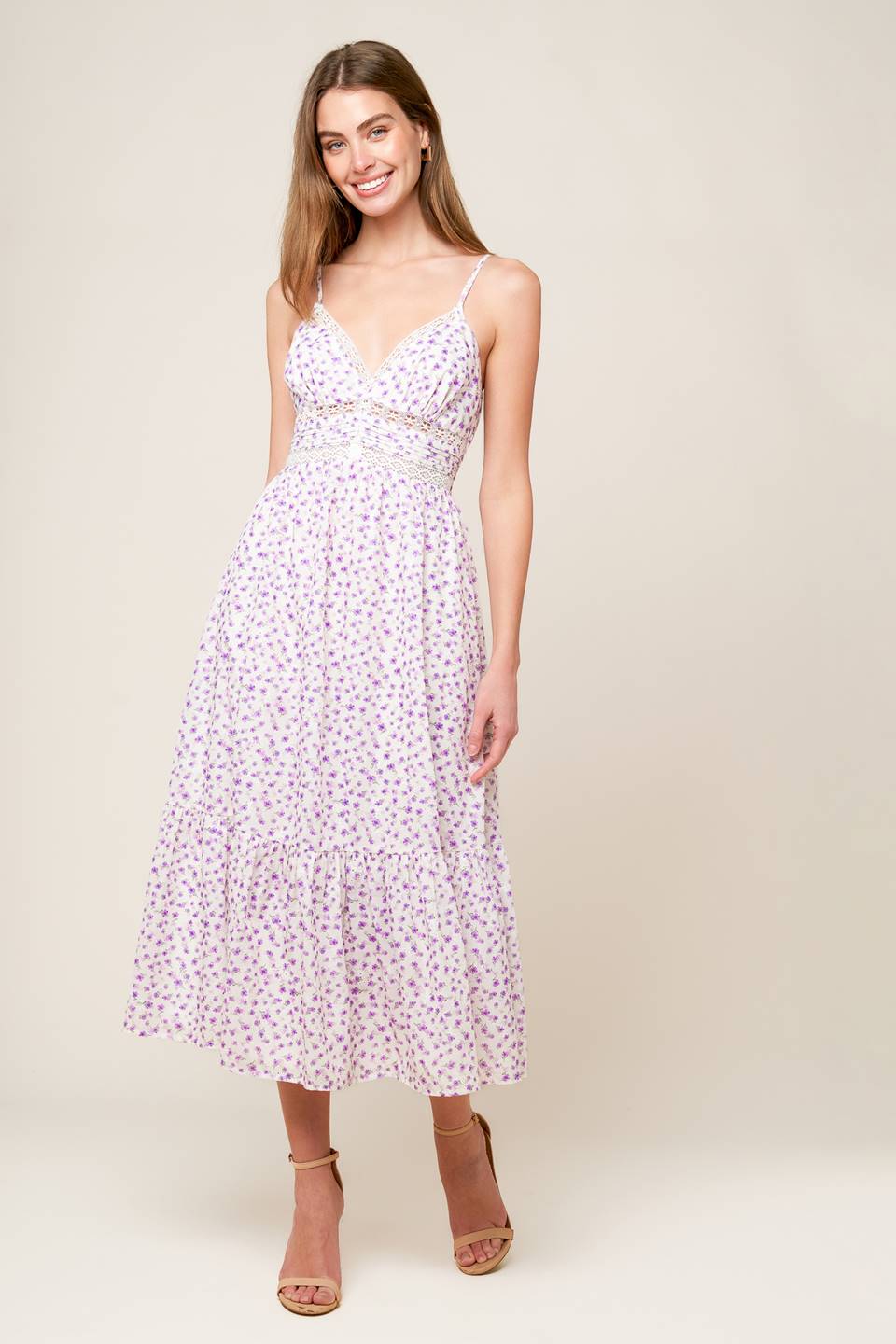 A white and lavender floral printed woven midi dress featuring cami top with straps, pleated waist band with lace inset, ruffled hemline and smocked back waistband.