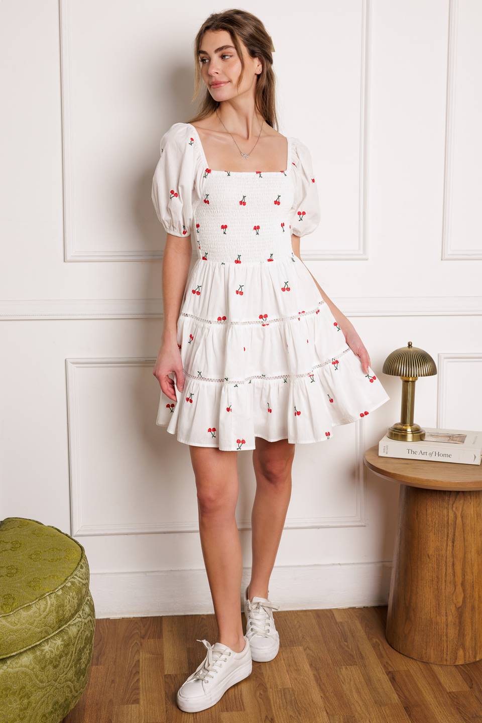 A cute embroidered mini dress with a square neckline, short puff sleeves, smocked bodice and a tiered skirt with lace detailing.