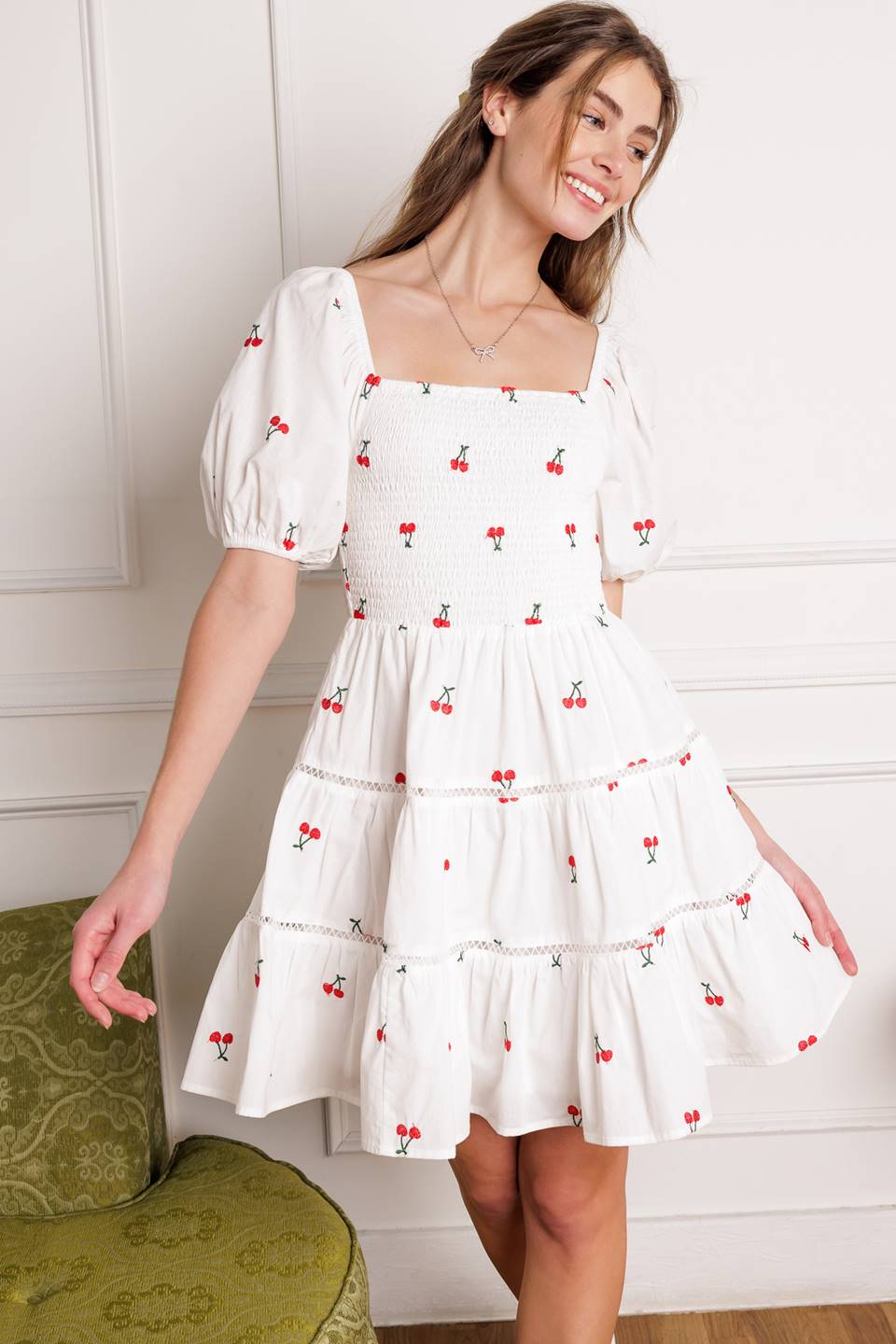 A cute embroidered mini dress with a square neckline, short puff sleeves, smocked bodice and a tiered skirt with lace detailing.