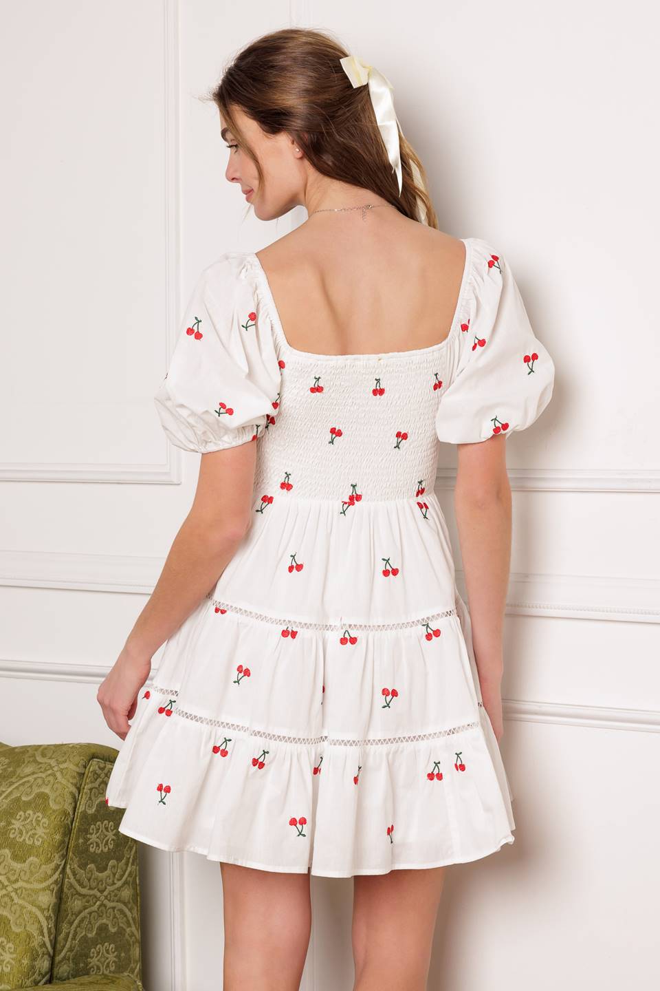 A cute embroidered mini dress with a square neckline, short puff sleeves, smocked bodice and a tiered skirt with lace detailing.