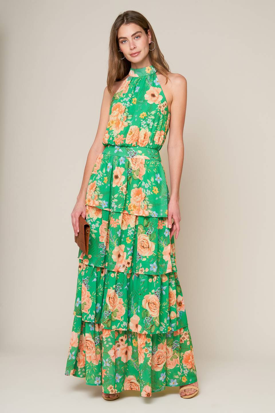 A printed woven maxi dress featuring halter neckline, sleeveless, layered skirt, back neck tie and smocked back waistband