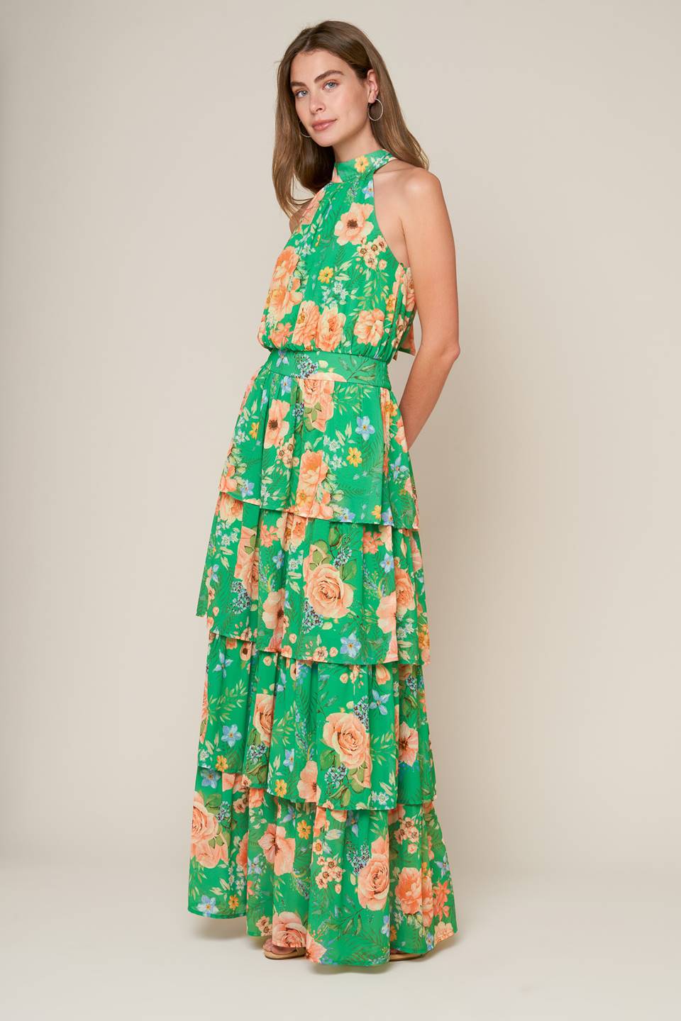 A printed woven maxi dress featuring halter neckline, sleeveless, layered skirt, back neck tie and smocked back waistband