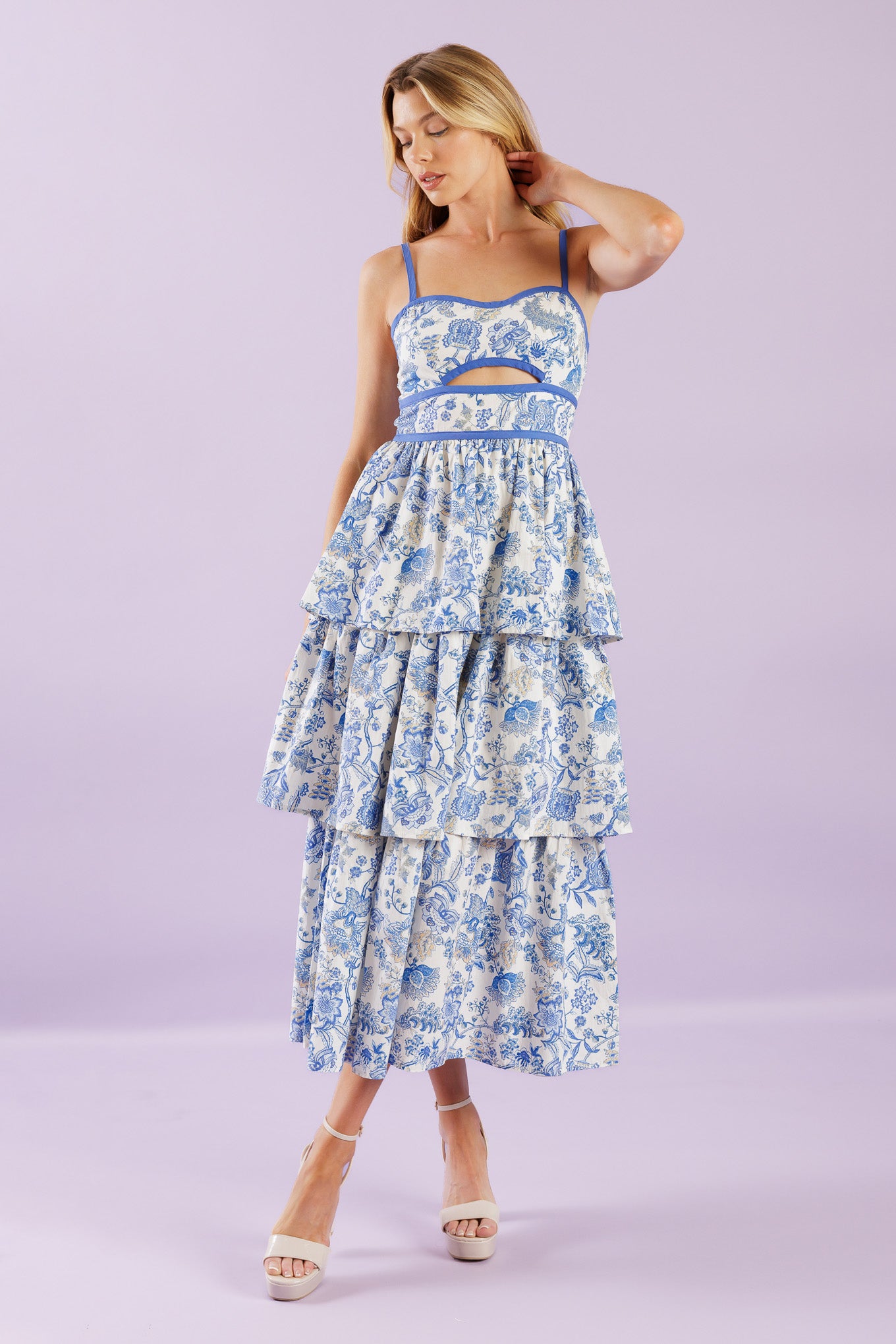 A printed woven midi dress featuring sweetheart neckline, straps, front bodice cut out, layered skirt and back zipper closure