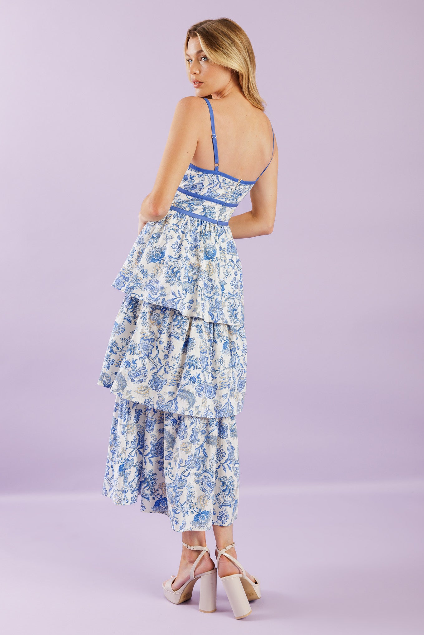 A printed woven midi dress featuring sweetheart neckline, straps, front bodice cut out, layered skirt and back zipper closure