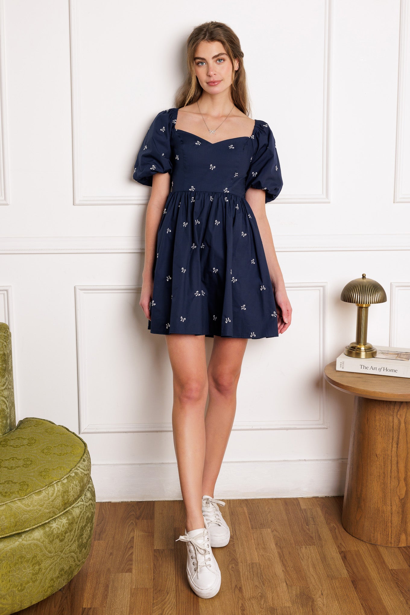 A woven mini dress with embroidery, sweetheart neckline, short puff sleeves, and a smocked back bodice, featuring a full skirt.