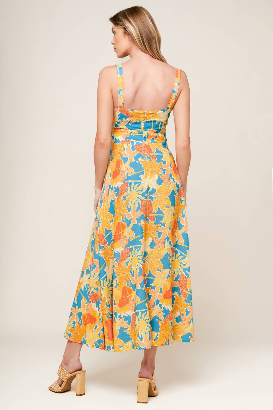 A printed woven midi dress featuring sweetheart neckline with twisted bodice detail, front cut out, straps, A line skirt and back zipper closure.