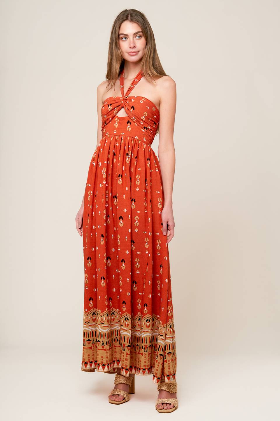 A printed woven maxi dress featuring halter neckline, center front cut out, wide waistband and smocked back bodies.