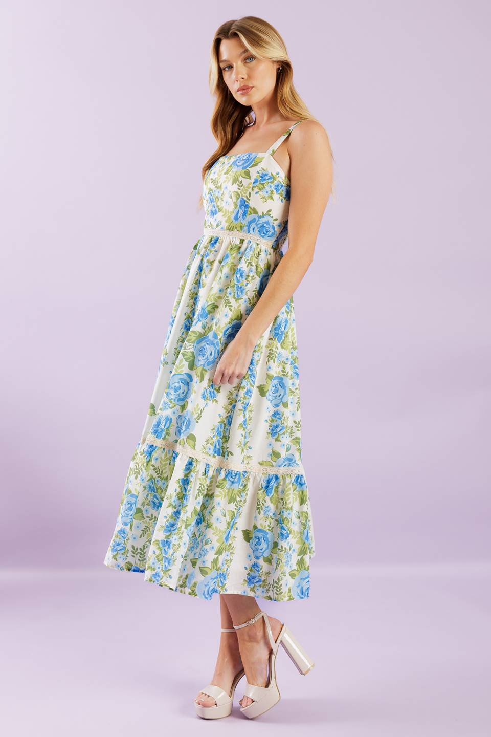 A woven midi dress printed with a straight neckline, straps, lace contrast, ruffled hemline and smocked back bodice.