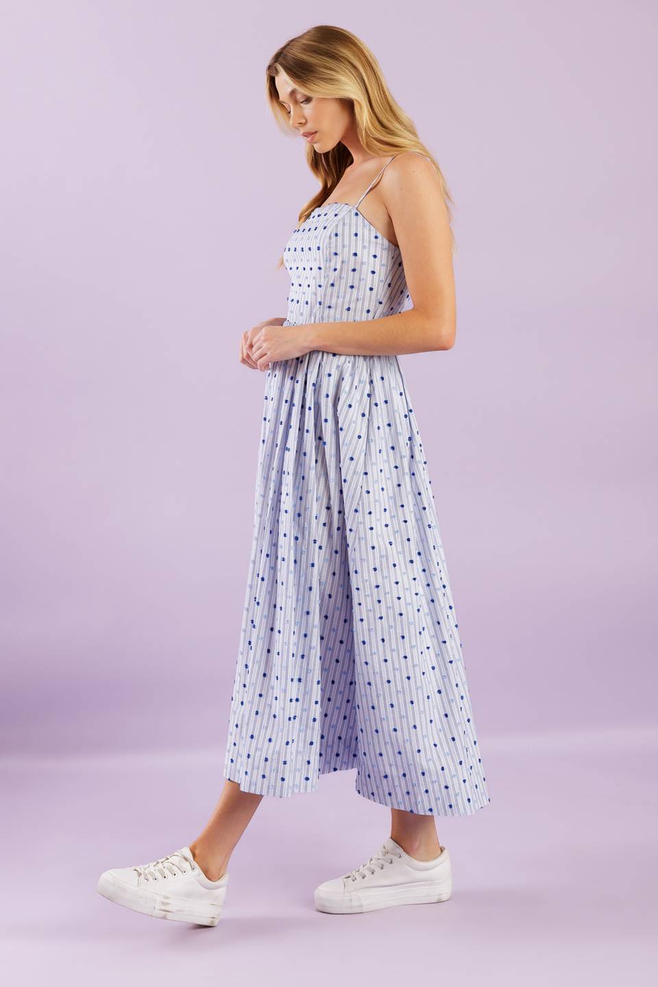 This woven midi dress boasts a textured striped design with a straight neckline, adjustable straps, a full skirt, and a back zipper closure for effortless wear.