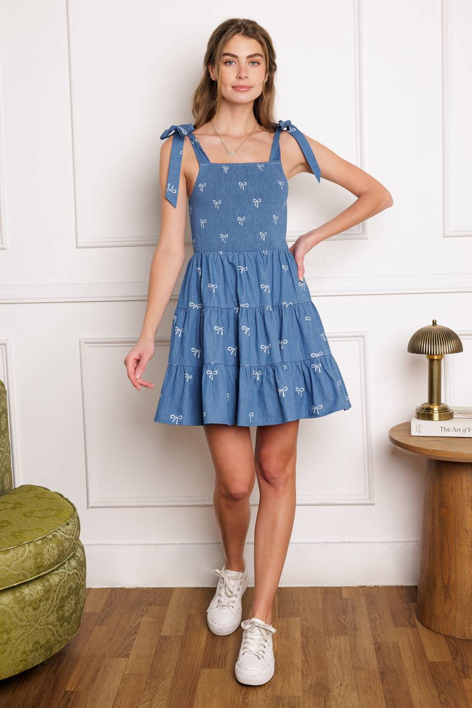 A chic woven mini dress with a solid embroidered design and charming shoulder ties, complete with a smocked bodice and tiered skirt.