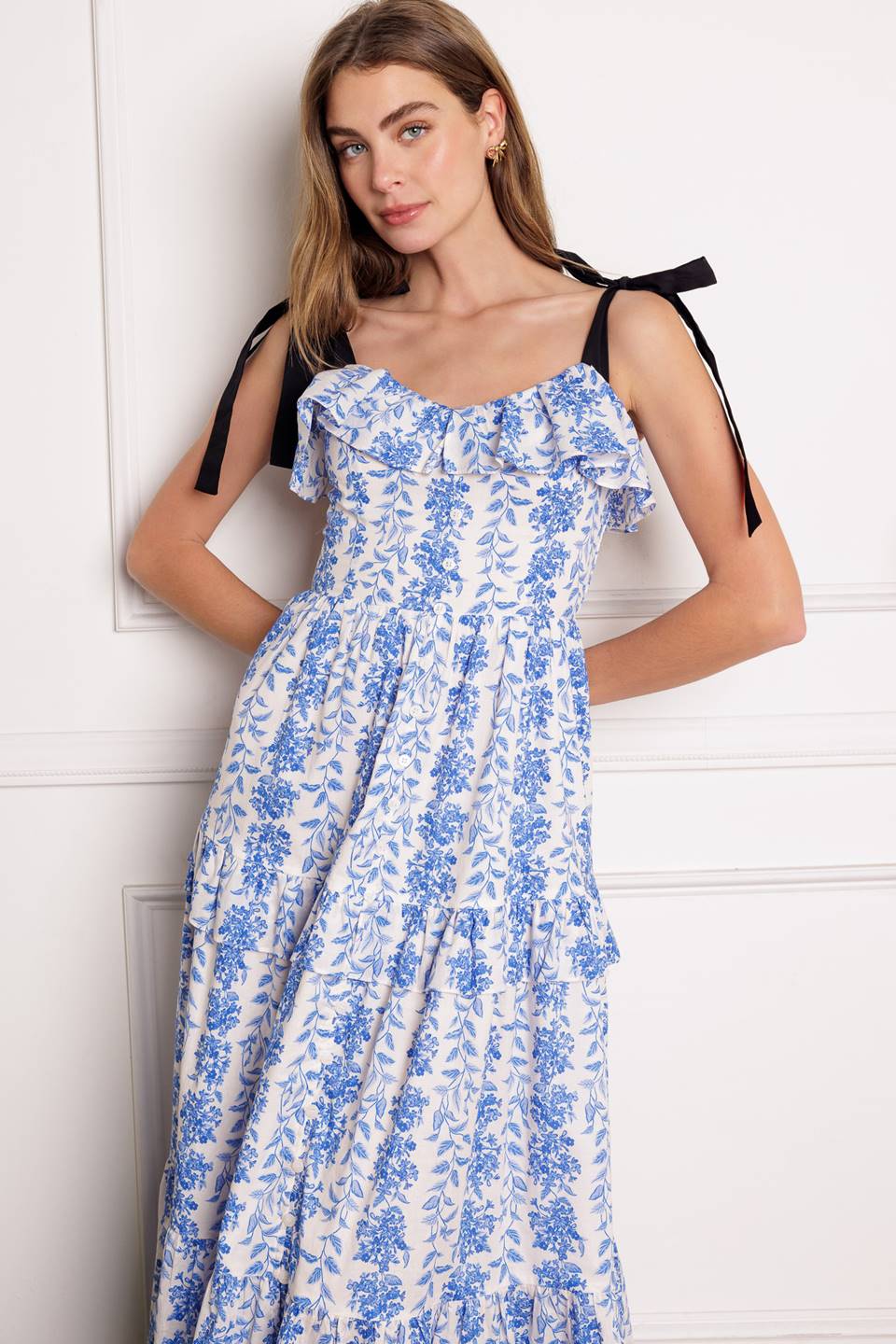 A charming midi dress with a sweetheart neckline, shoulder ties, tiered ruffle skirt, and smocked back bodice.