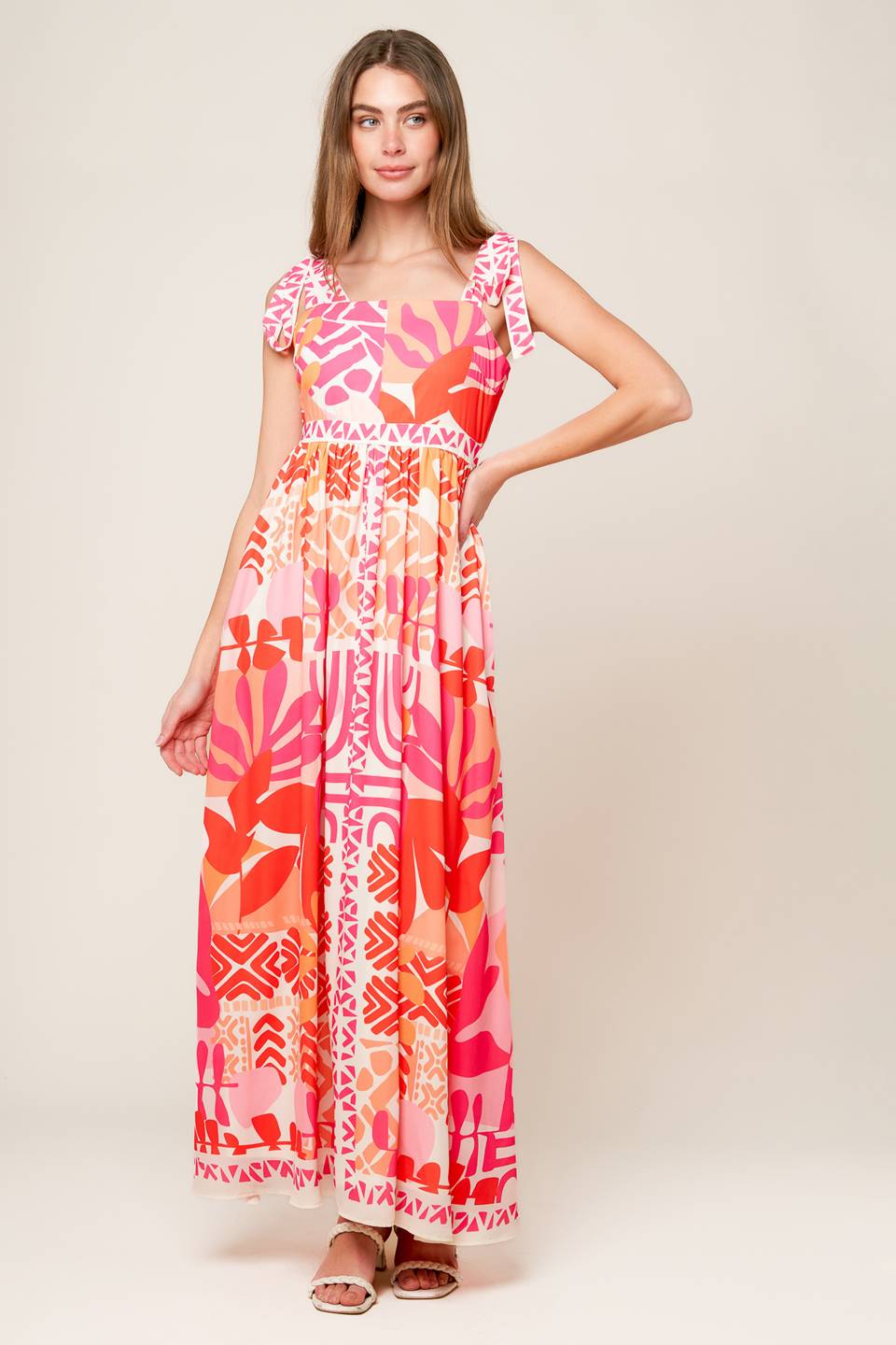 A printed woven maxi dress featuring straight neckline, shoulder tie and back zipper closure.