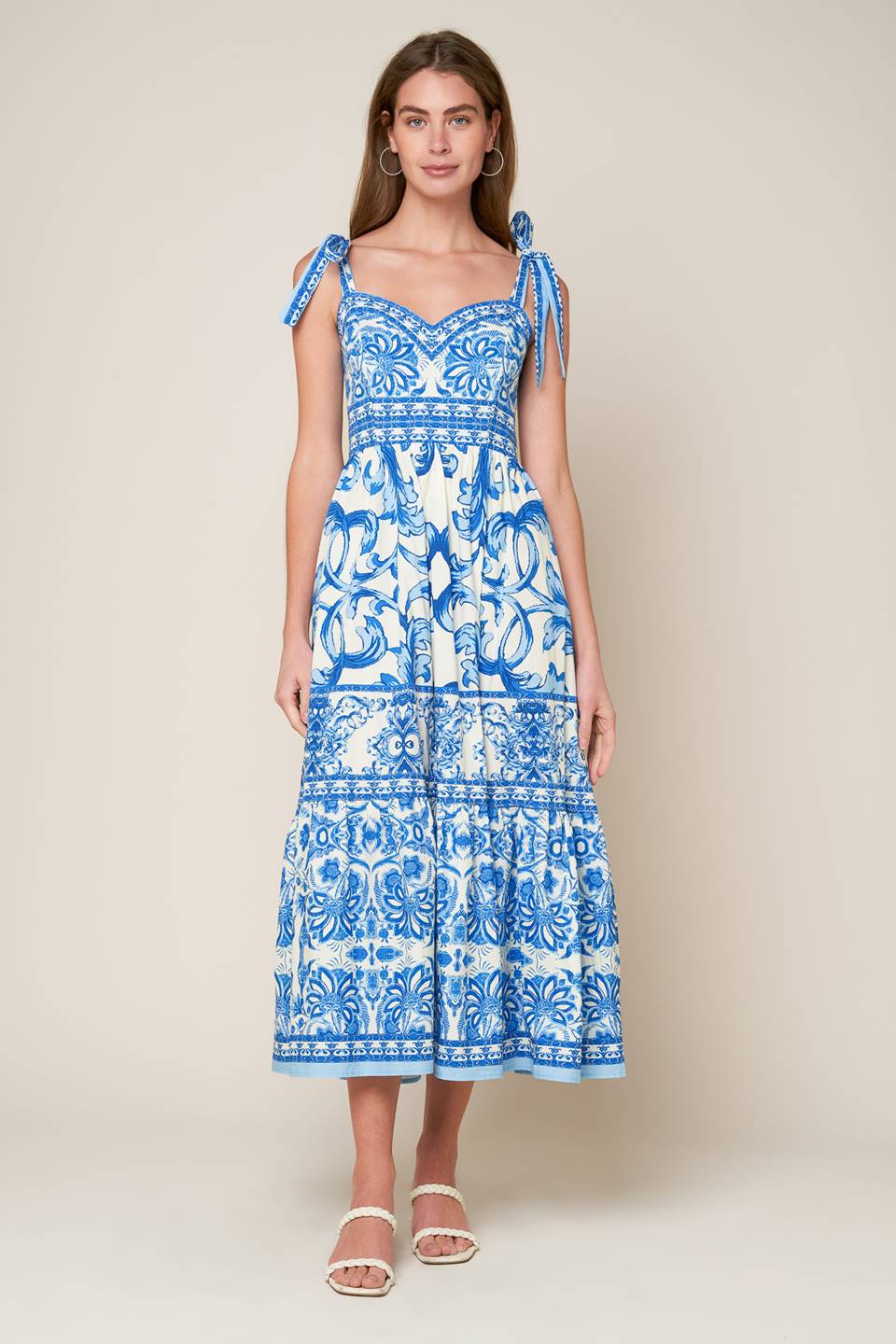 A printed woven midi dress featuring sweetheart neckline, shoulder ties, ruffled hemline and smocked back bodice