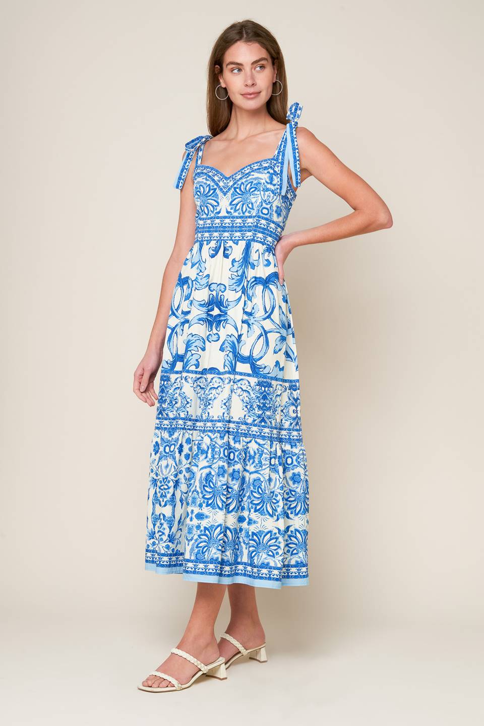 A printed woven midi dress featuring sweetheart neckline, shoulder ties, ruffled hemline and smocked back bodice