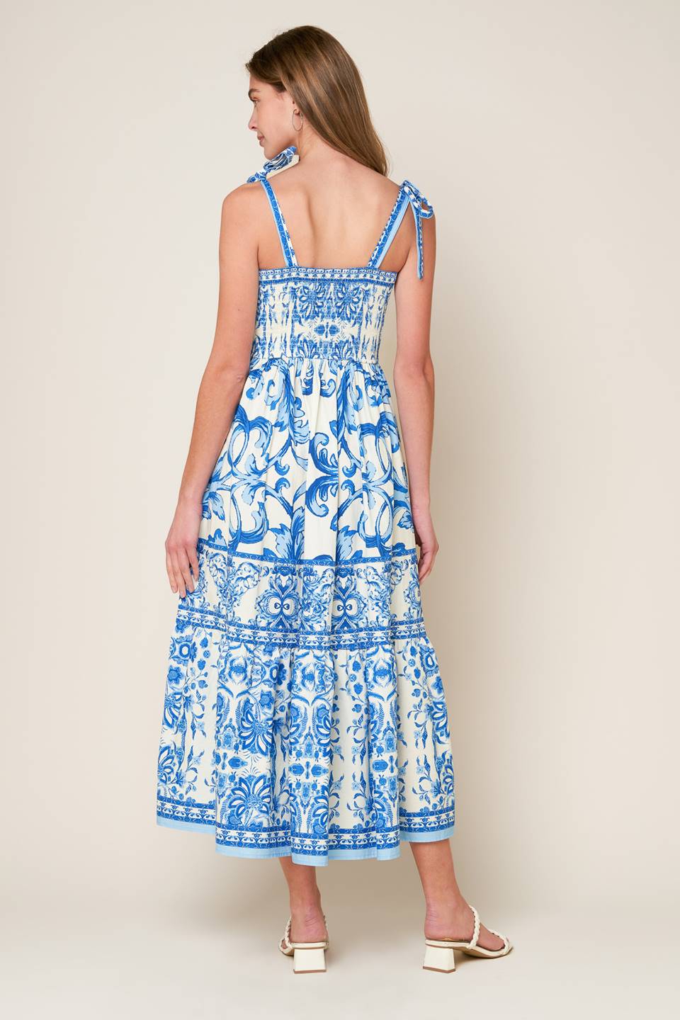 A printed woven midi dress featuring sweetheart neckline, shoulder ties, ruffled hemline and smocked back bodice