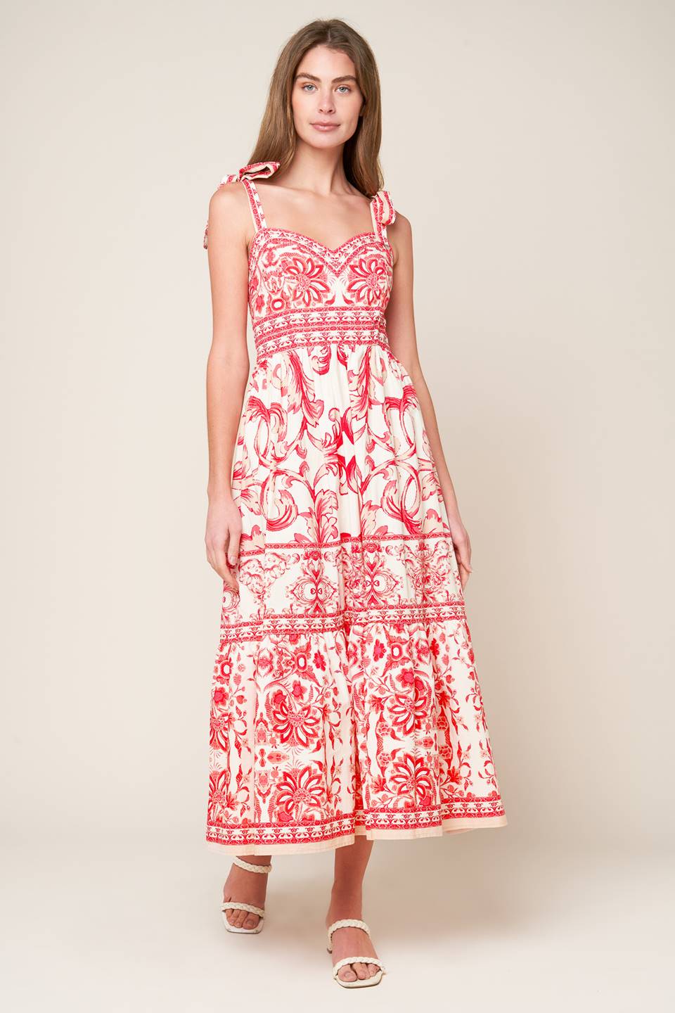 A printed woven midi dress featuring sweetheart neckline, shoulder ties, ruffled hemline and smocked back bodice