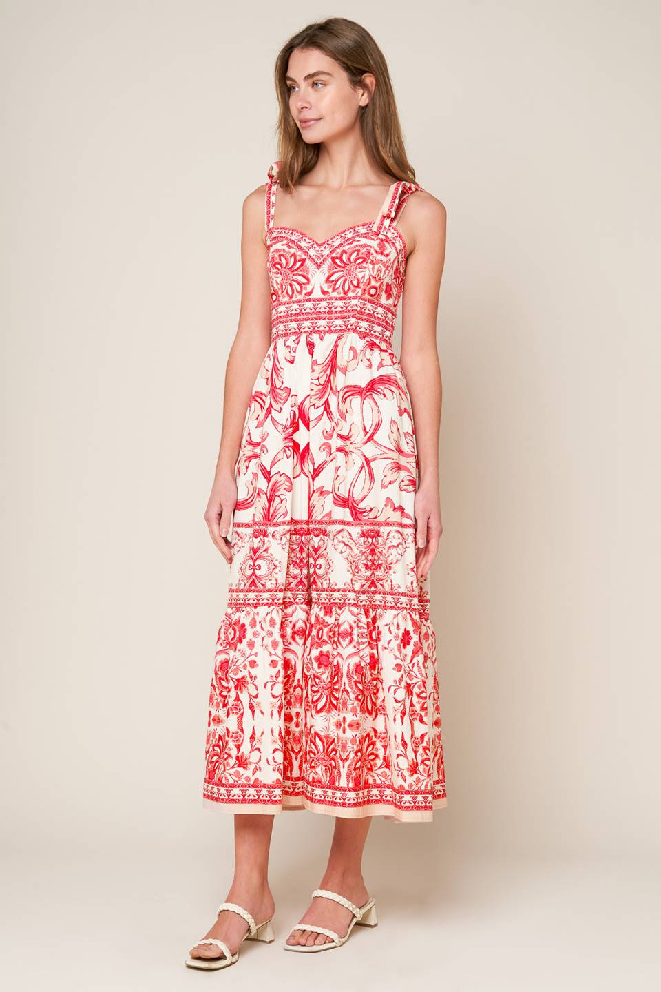 A printed woven midi dress featuring sweetheart neckline, shoulder ties, ruffled hemline and smocked back bodice