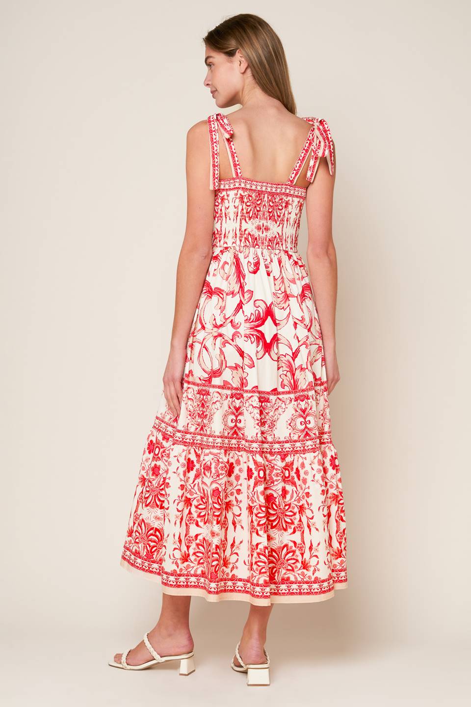 A printed woven midi dress featuring sweetheart neckline, shoulder ties, ruffled hemline and smocked back bodice