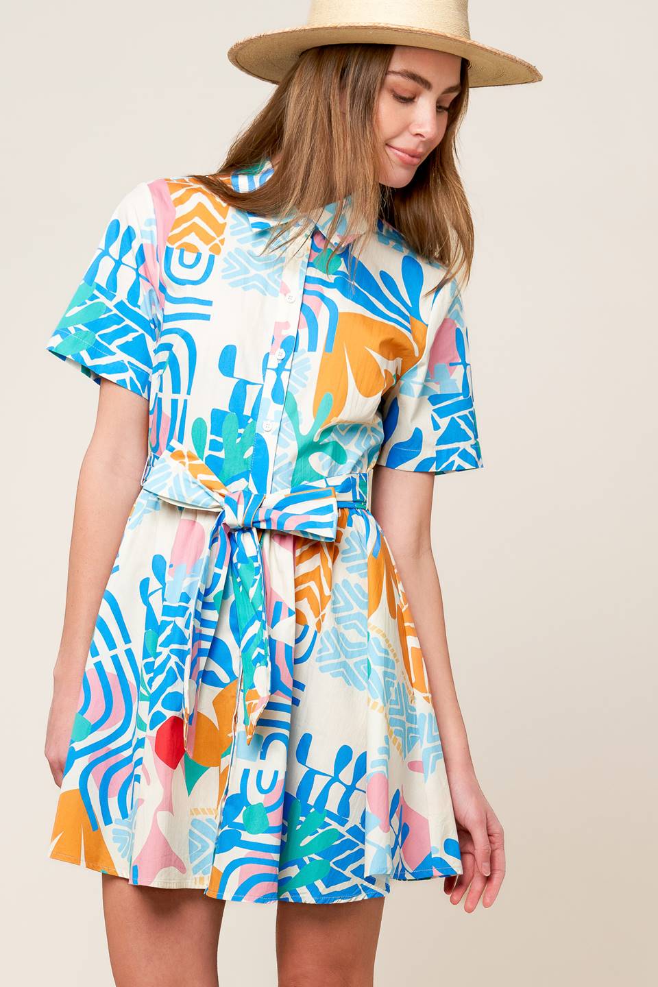 A printed woven mini dress featuring collar, button down, short sleeve and self sash tie