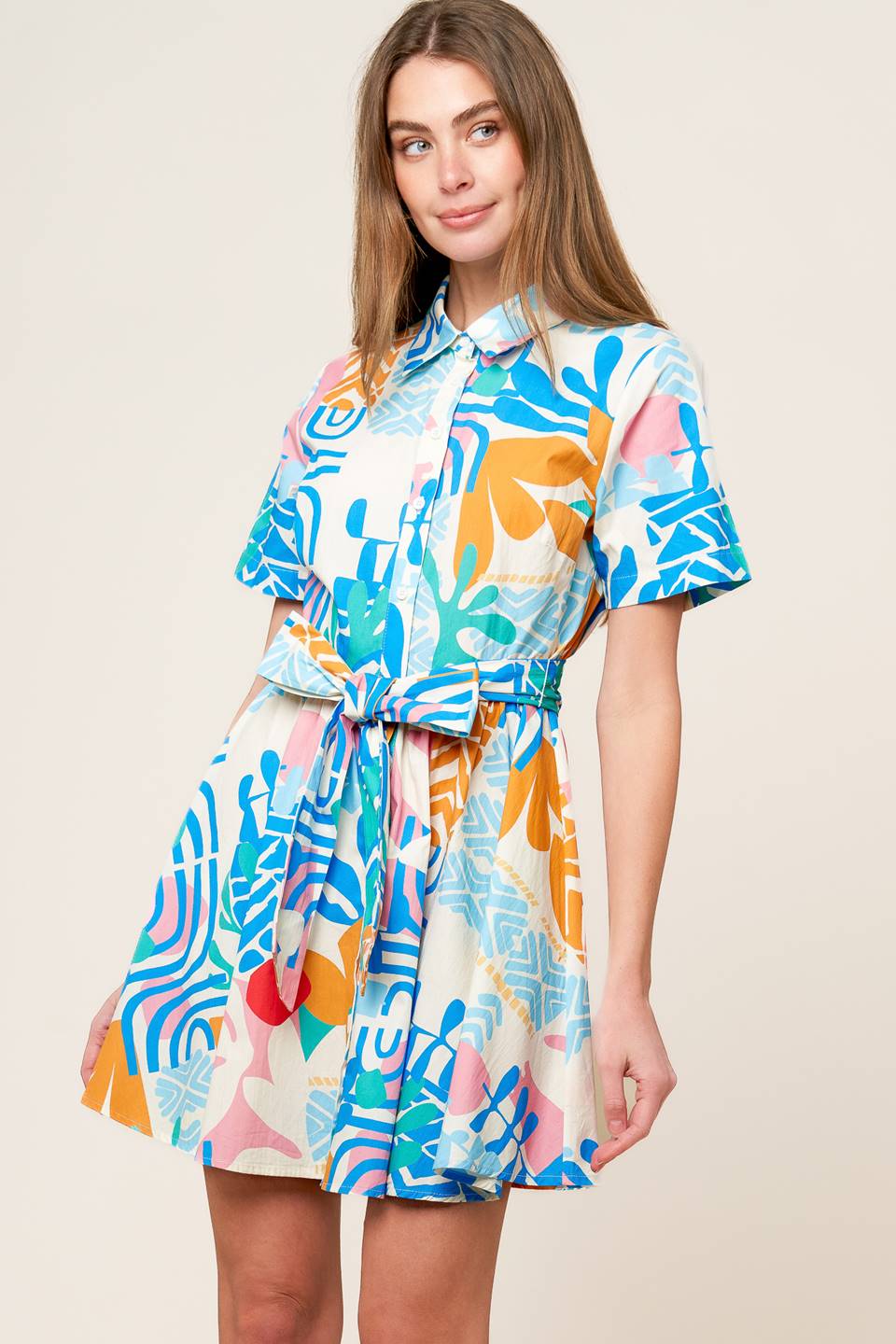 A printed woven mini dress featuring collar, button down, short sleeve and self sash tie