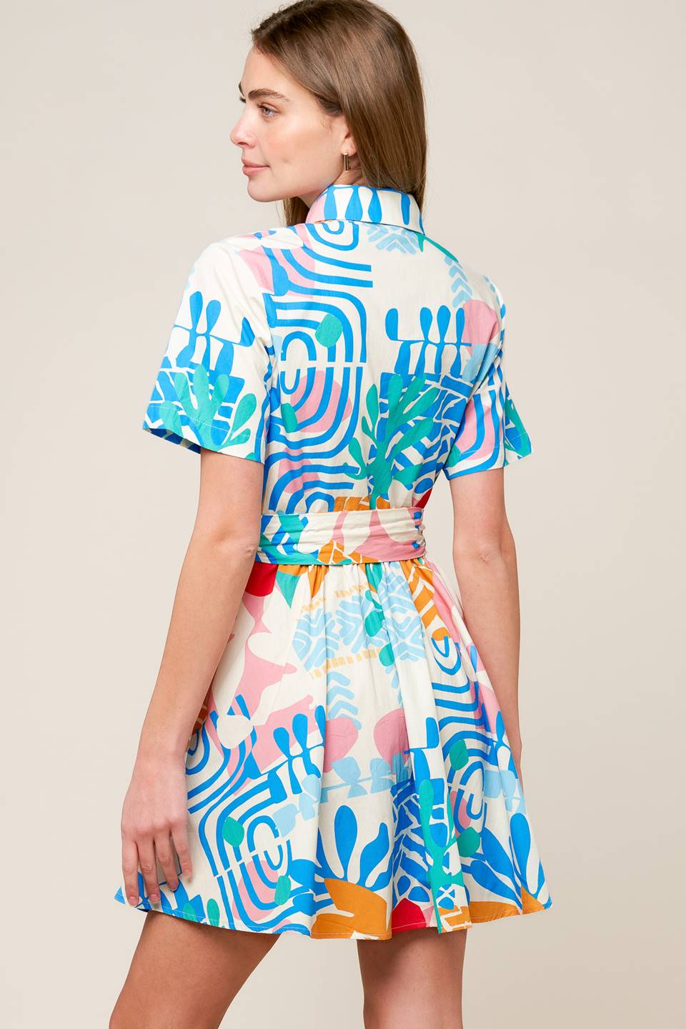 A printed woven mini dress featuring collar, button down, short sleeve and self sash tie